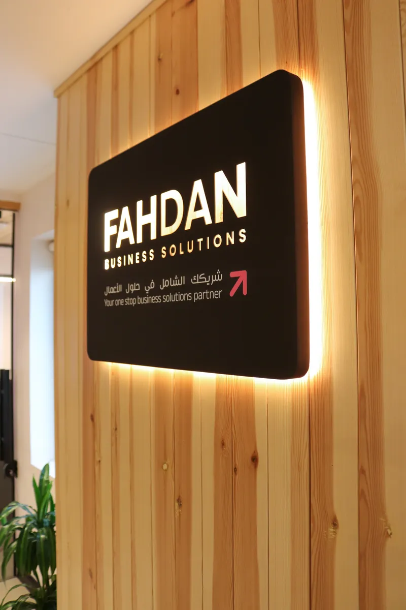 2nd floor · the backlit FAHDAN Business Solutions sign on the reception's timber wall