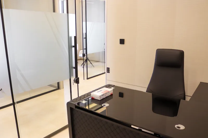 Office 61 · desk and high-back chair beside a glass door with a frosted band