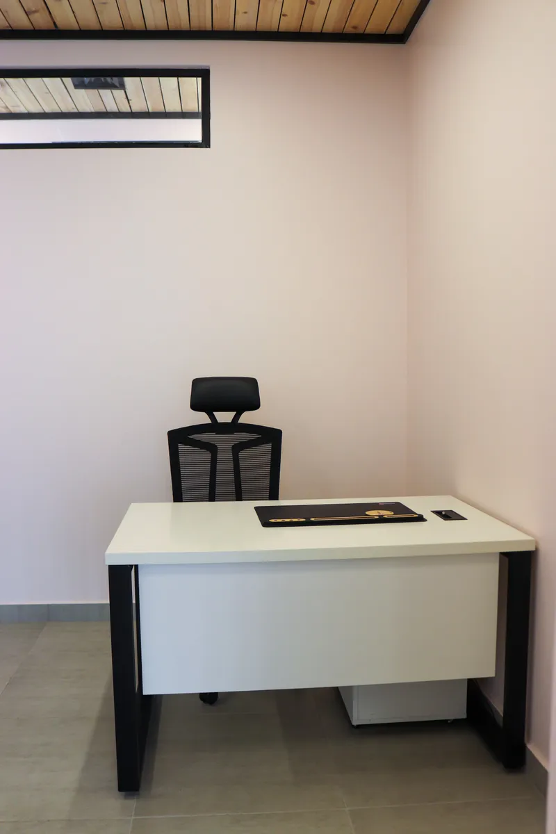 Office 68 · desk and high-back mesh chair beneath a high interior window