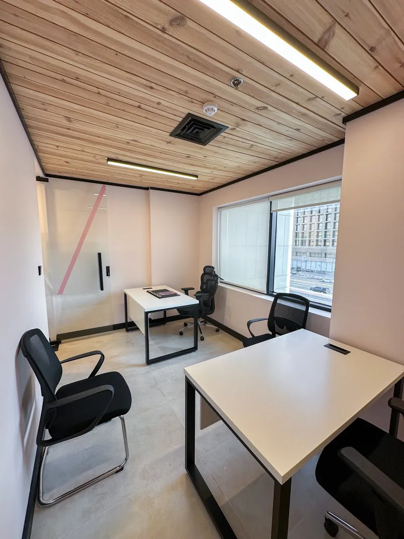 Office 33 · two desks and chairs beside the pink-striped glass door, with a window