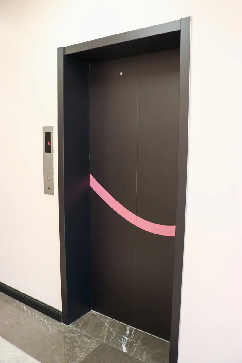 14th floor · lift door with a curved pink stripe