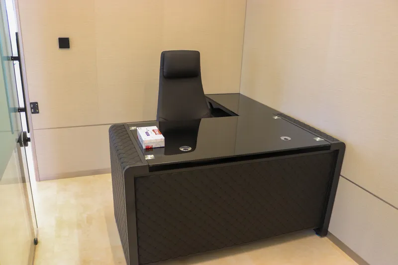 Office 61 · L-shaped glass-top desk and high-back chair