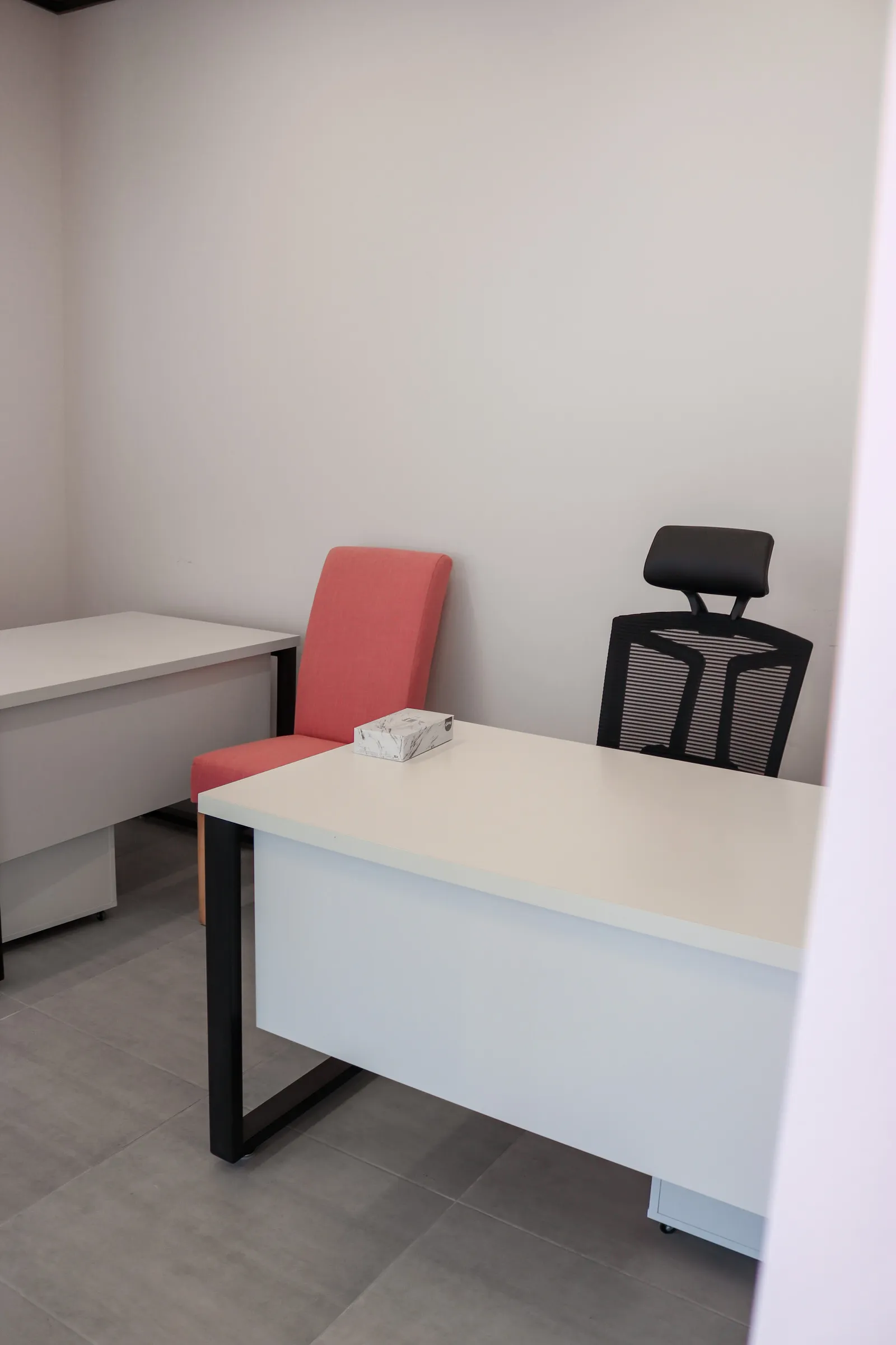 Office 67 · two desks, a high-back mesh chair and a pink upholstered chair