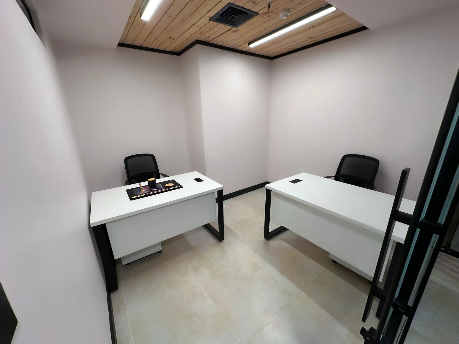 Office 27 · two white desks with mesh chairs under a wood-slat ceiling