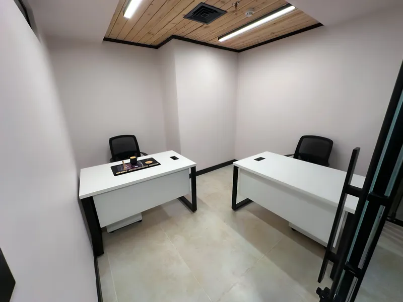 Office 27 · two white desks with mesh chairs under a wood-slat ceiling