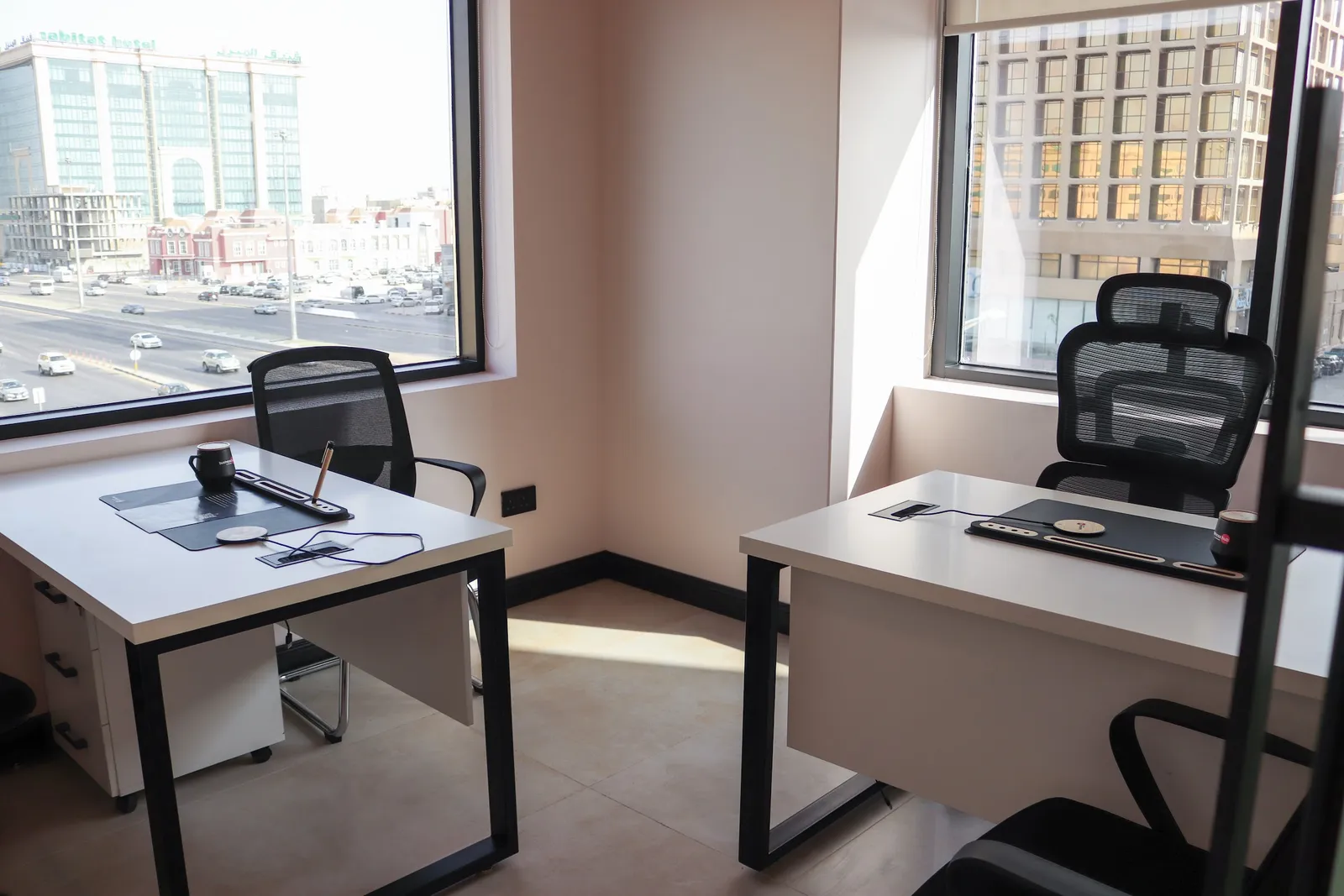 Office 36 · corner room with two windows over the street, two desks and mesh chairs