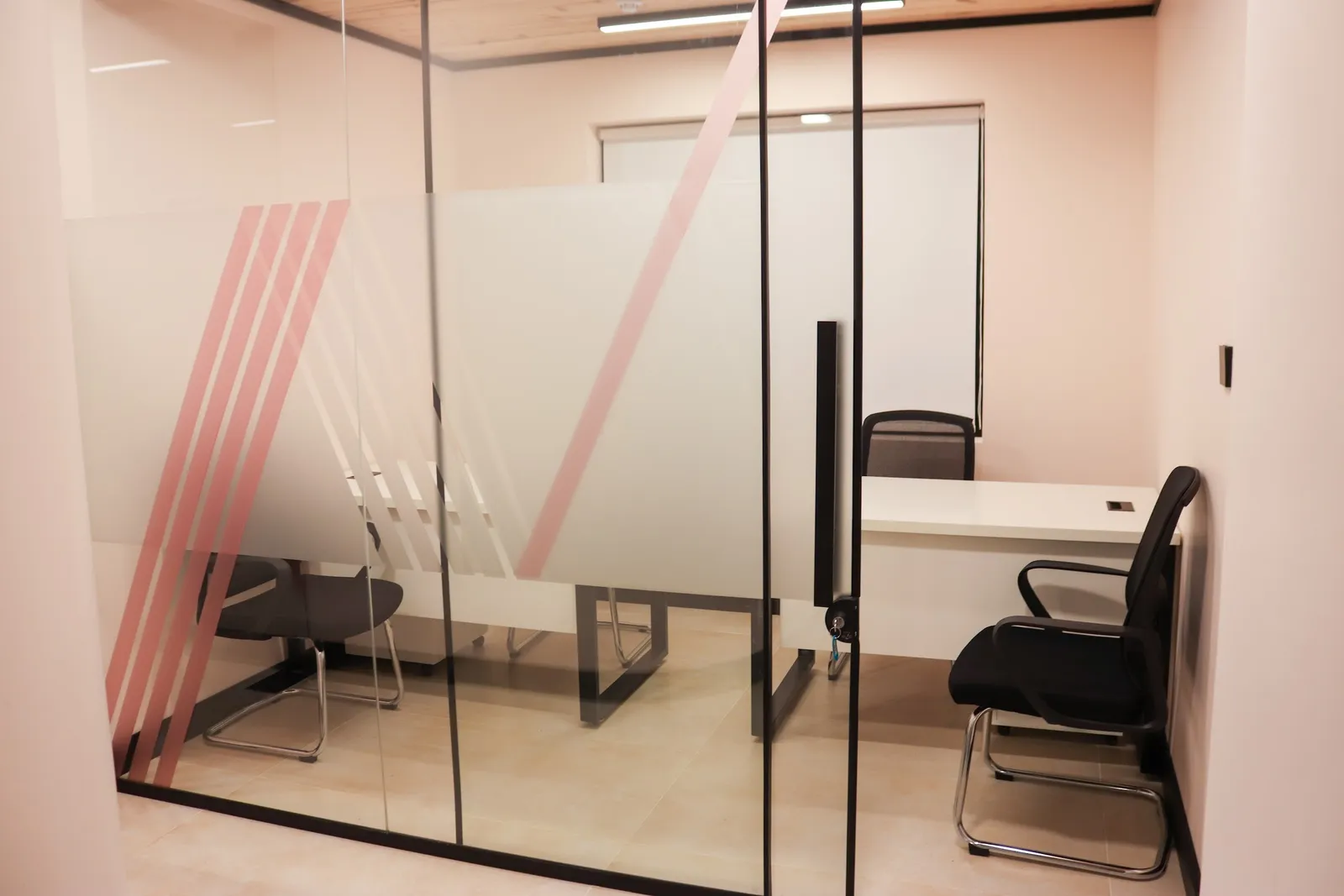 Office 30 · glass front with a frosted band and pink stripes, showing desks and mesh chairs