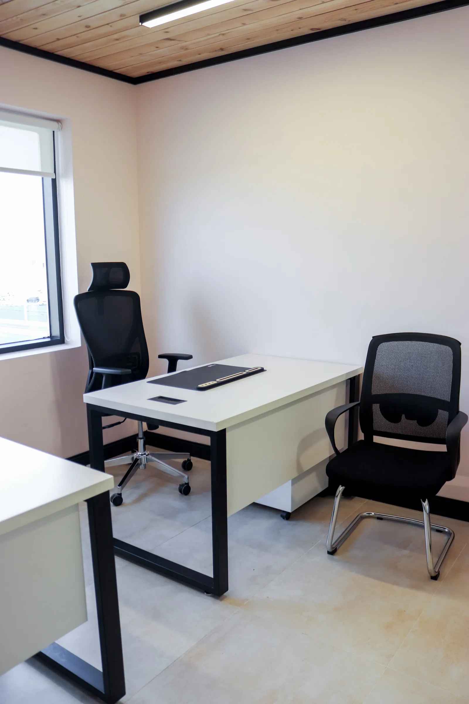 Office 40 · desk with a desk mat, a high-back mesh chair and a visitor chair, window on the left
