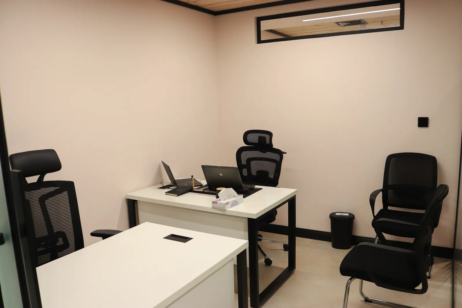 Growth Office · two white desks with mesh chairs and two visitor chairs against light pink walls