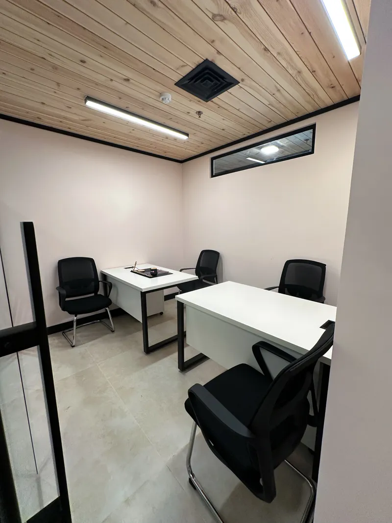 Office 2 · two desks with four mesh chairs, a wooden ceiling and a high window strip