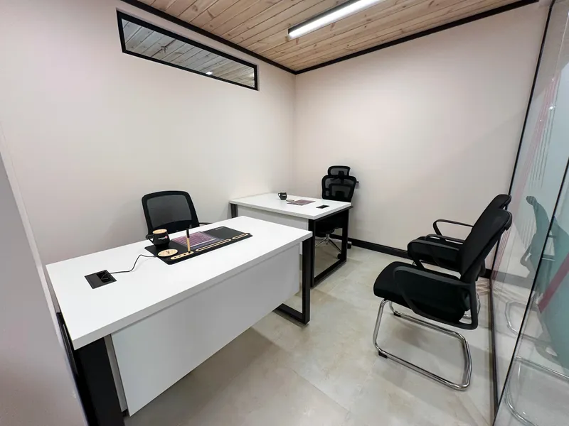 Office 47 · two desks with mesh chairs, two visitor chairs and a glass wall under a wooden ceiling