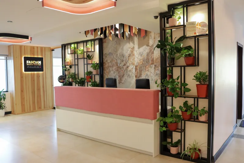 2nd floor · reception with a pink desk, plant shelving and a backlit sign on a timber wall