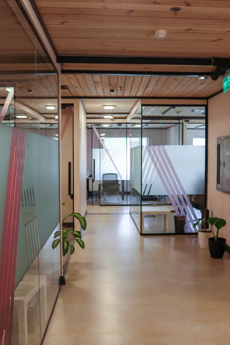 2nd floor · corridor between glass-walled rooms with pink-striped frosting and potted plants