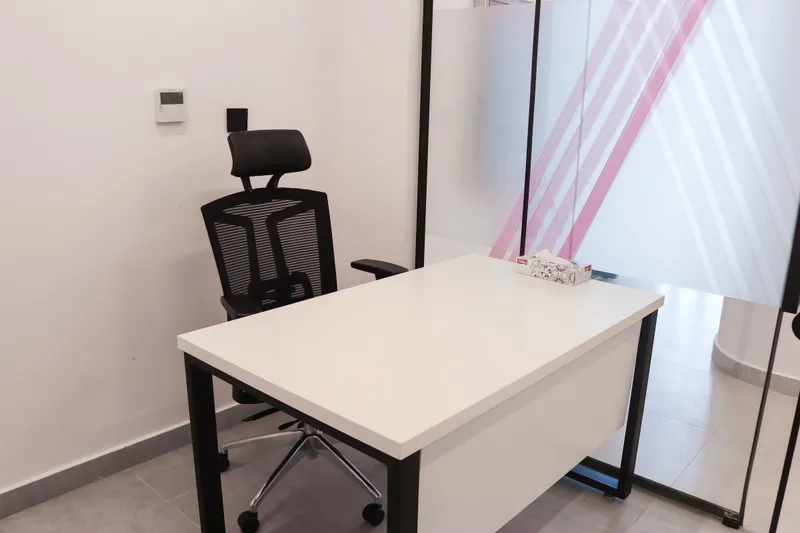 Office 69 · desk and high-back mesh chair beside a frosted glass front with pink stripes