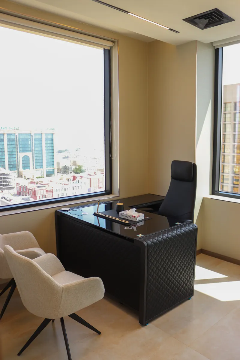 Office 53 · corner with two windows, desk and two guest armchairs
