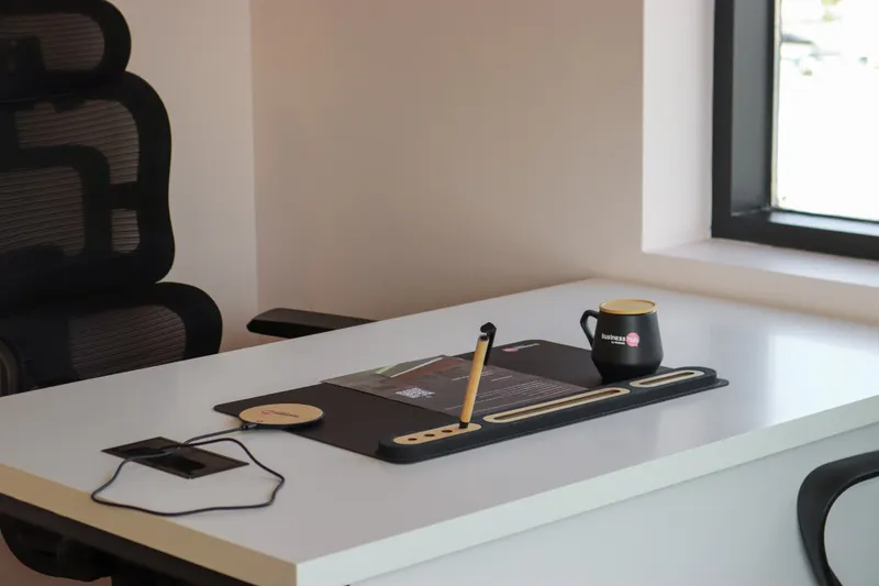 Office 36 · desk by the window with a desk mat, wireless charger and mug
