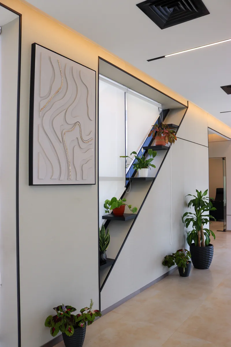 13th floor · feature wall with textured wall art and a diagonal shelf of potted plants