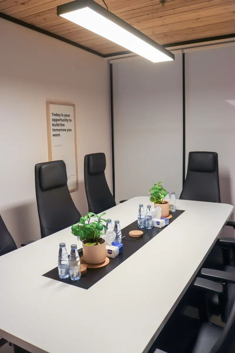 Meeting table with plants, a framed quote print and a pendant light