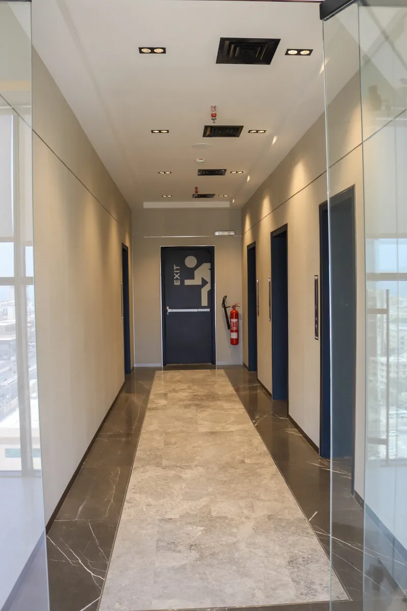 13th floor · lift lobby with a marble floor, dark lift doors and a fire exit