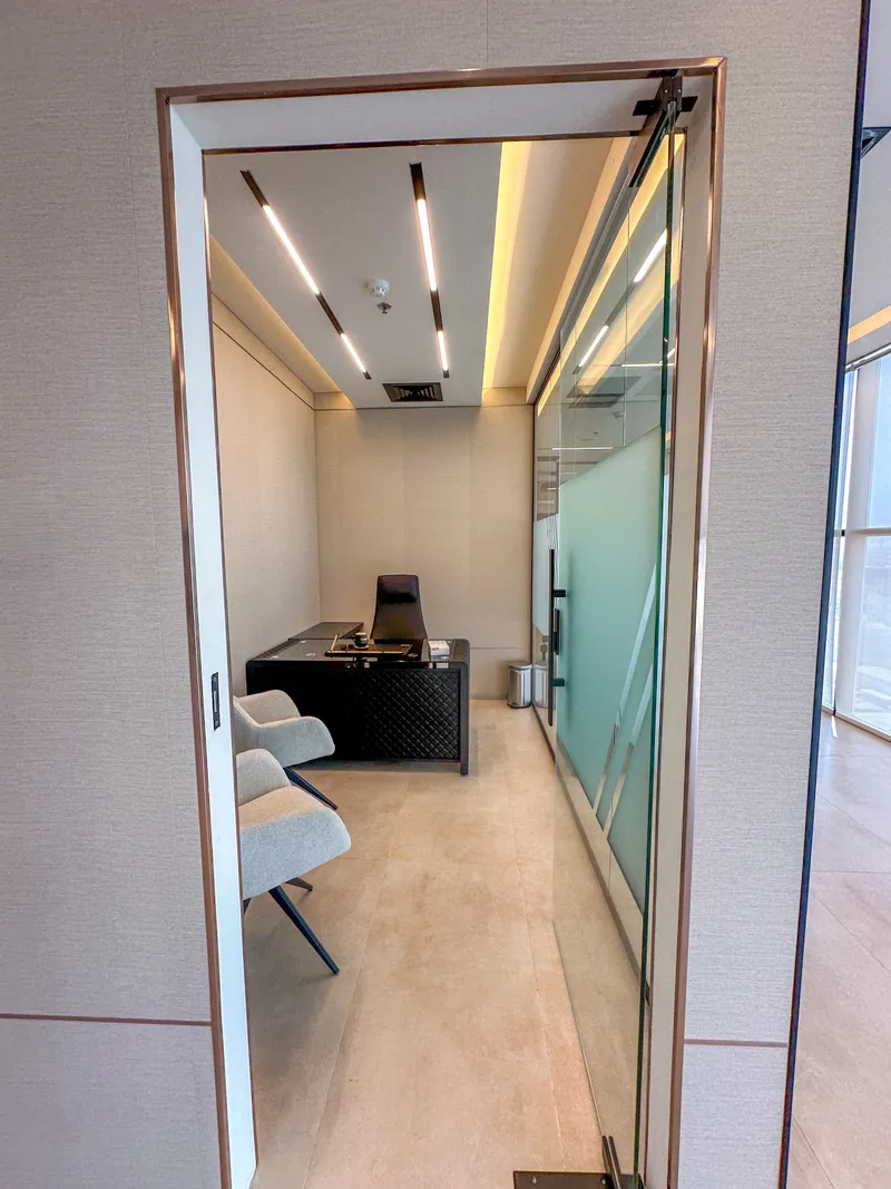Office 62 · entrance view with glass door, desk and two guest armchairs