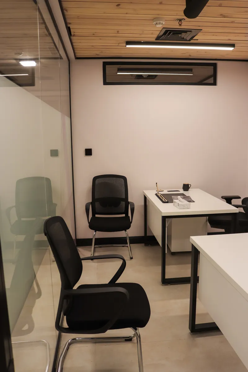 Growth Office · visitor chairs and a desk under a high window strip, glass front on the left