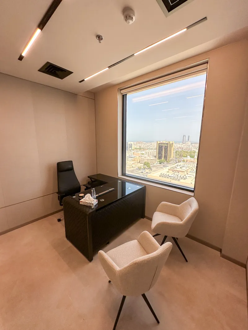 Office 55 · full room with desk, two guest armchairs and a window over the city