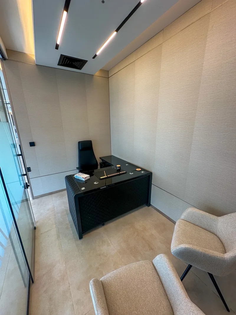 Office 63 · full room: L-shaped desk, high-back chair and guest armchairs