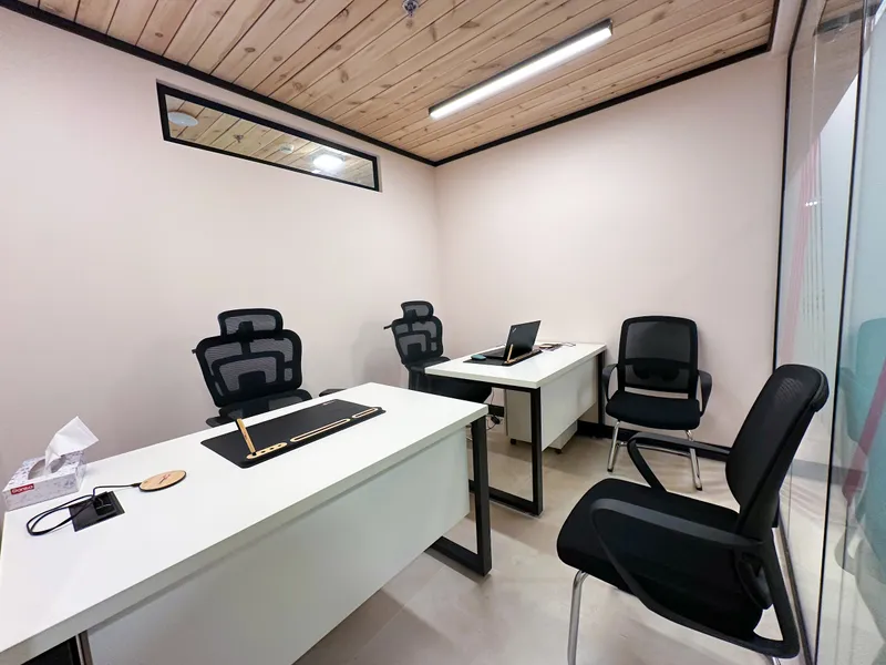 Growth Office · two desks, high-back and visitor chairs, and a glass wall under a wooden ceiling