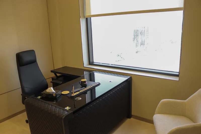Office 56 · L-shaped desk and executive chair beside the window