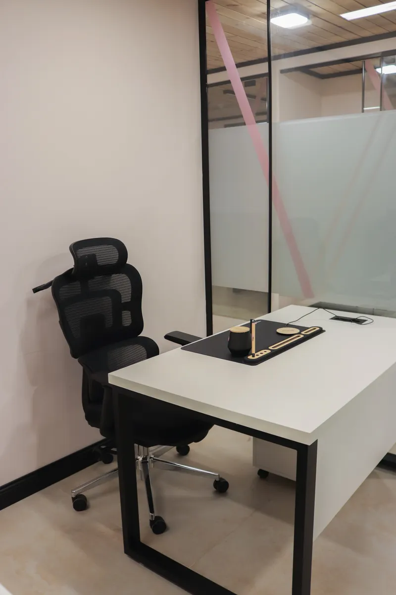 Growth Office · desk with an ergonomic chair beside the frosted glass front with pink stripes