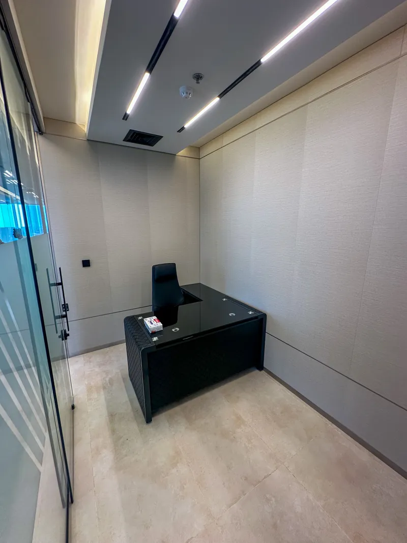Office 61 · corner desk, open floor space and textured wall panels