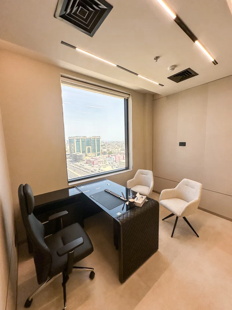 Office 55 · executive chair, desk and two guest armchairs facing a city-view window