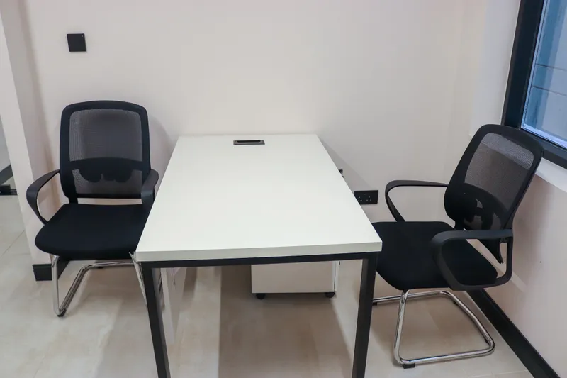 Office 19 · white desk with a drawer unit and two visitor chairs beside a window
