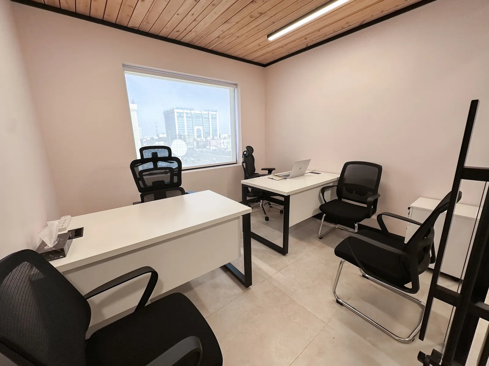 Office 42 · two desks, five chairs and a drawer unit under a wooden ceiling, with a window