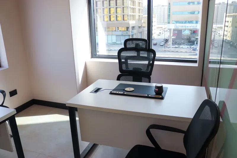 Office 36 · desk and mesh chair in front of the window, glass partition on the right