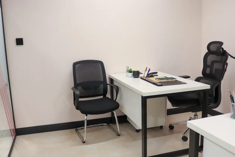 Office 17 · desk with a notebook and a plant between a visitor chair and an ergonomic chair