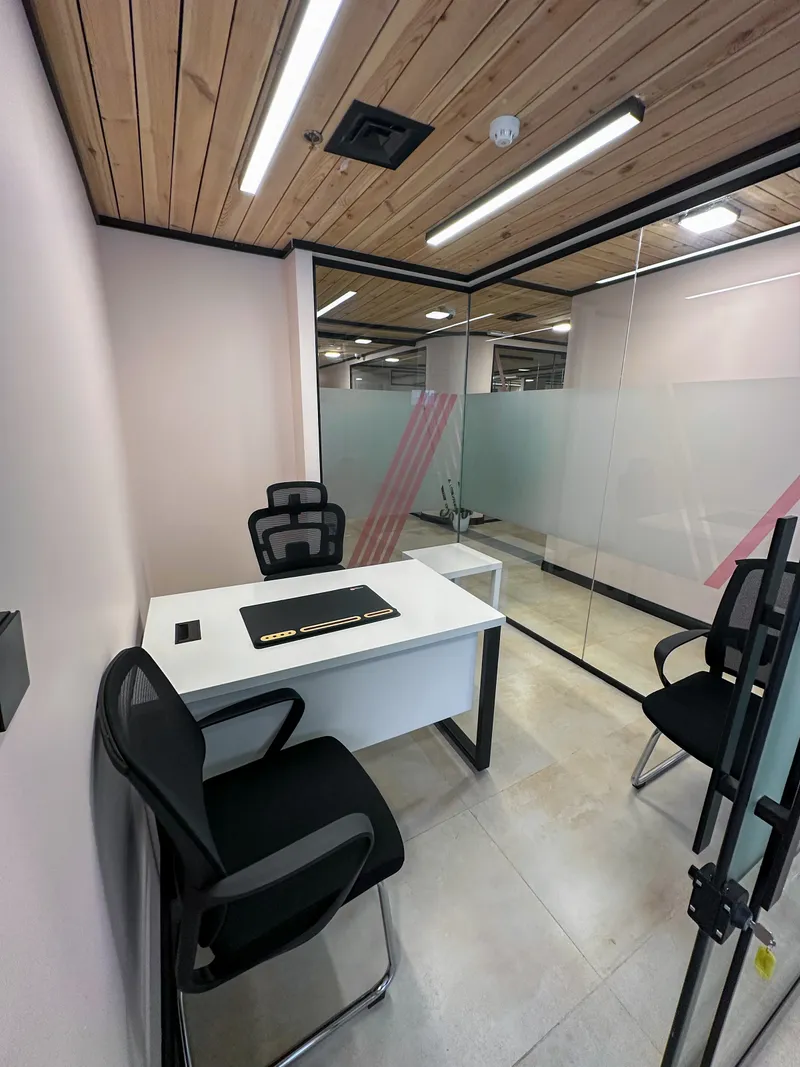 Office 34 · desk with a high-back chair, two visitor chairs and a side table under a wooden ceiling