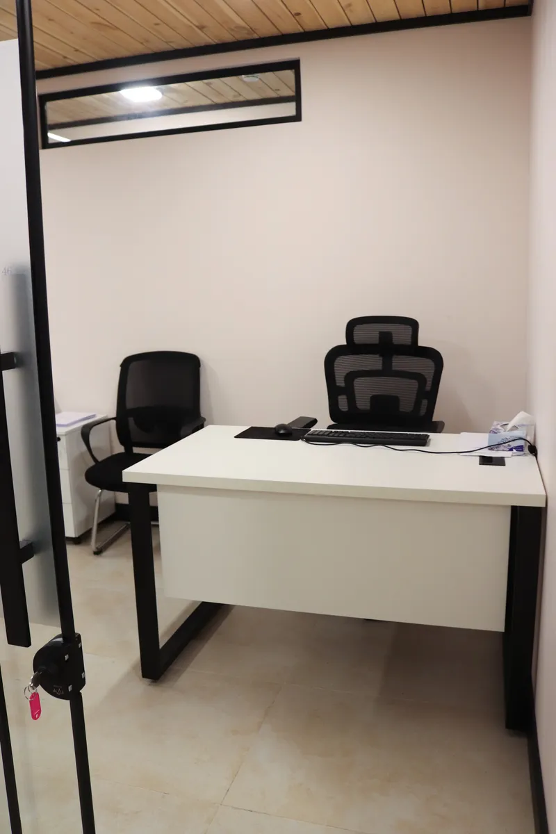 Office 46 · white desk with a high-back chair and a visitor chair, seen from the glass door