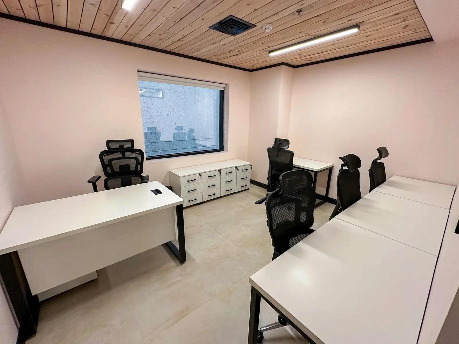 Office 25 · desks, high-back mesh chairs and drawer units around a window with a roller blind