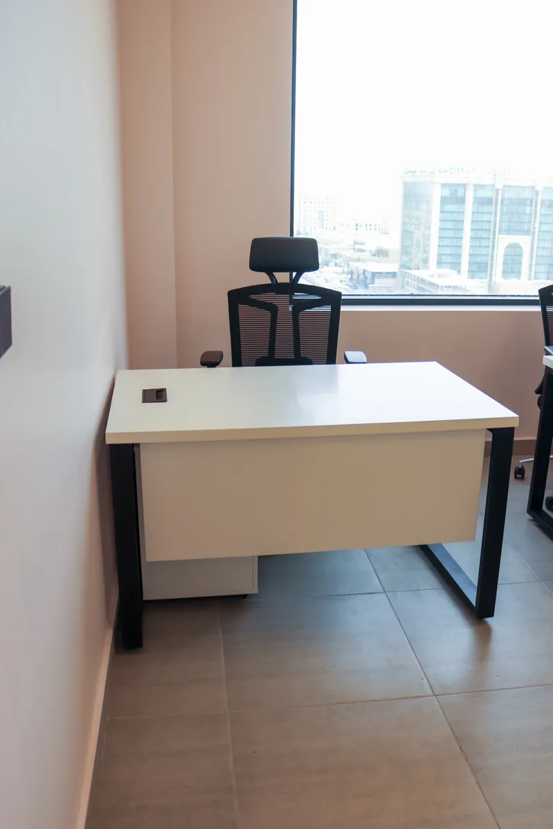 Office 65 · single desk and mesh task chair facing the window