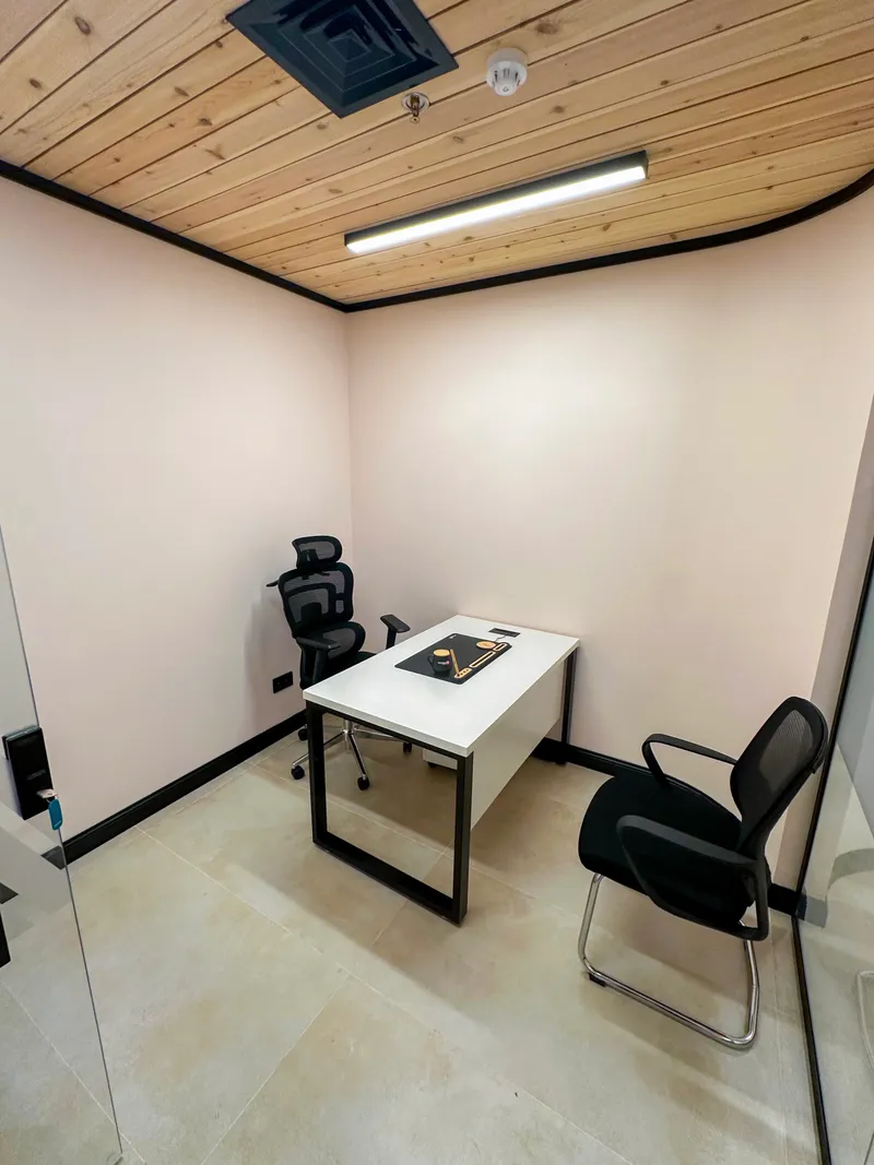 Office 32 · desk with a high-back mesh chair and a visitor chair under a pine-slat ceiling