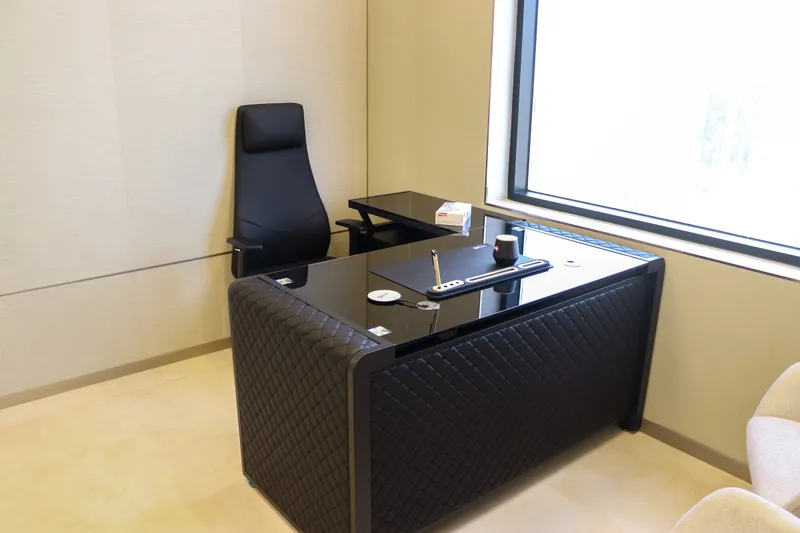 Office 54 · L-shaped desk and executive chair beside the window