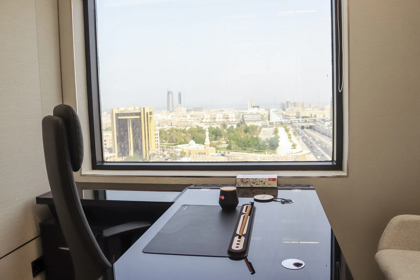 Office 57 · desk and high-back chair facing a large window over the city