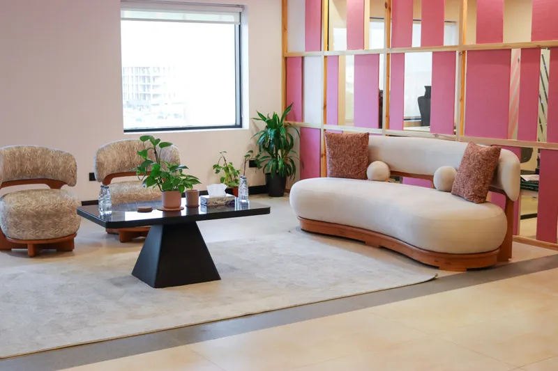 2nd floor · curved sofa, two armchairs and a black coffee table beside a pink slatted partition