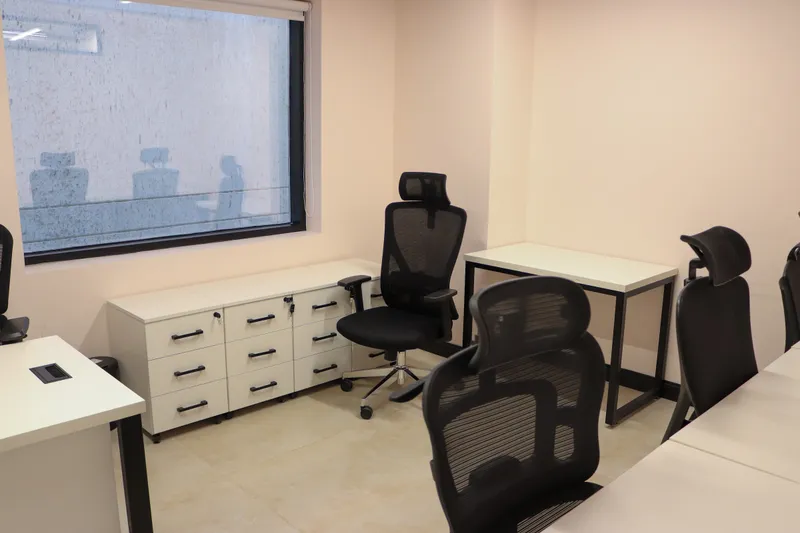 Office 25 · mesh chairs, drawer units and a desk beside a window with a roller blind