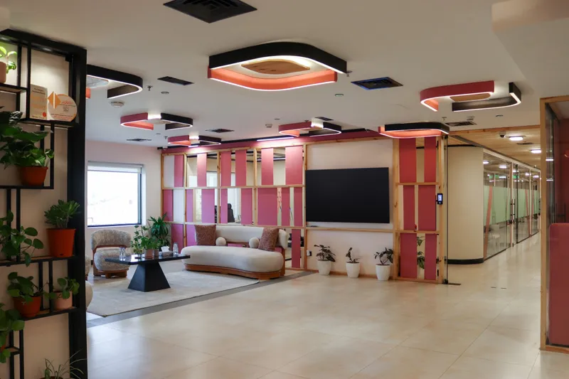 2nd floor · lounge and the corridor beyond, with pink ceiling lights and plant shelving